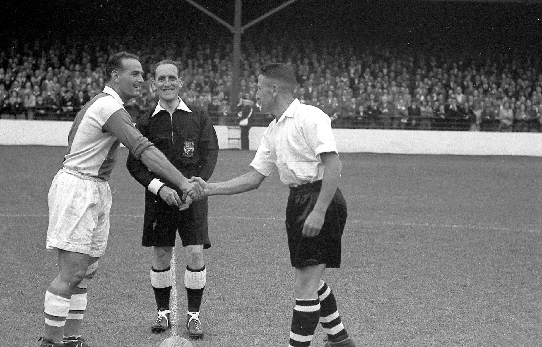 Bud Aherne greets Oldham skipper George Hardwick. The referee,, a smiling Mr Richardson, watches on