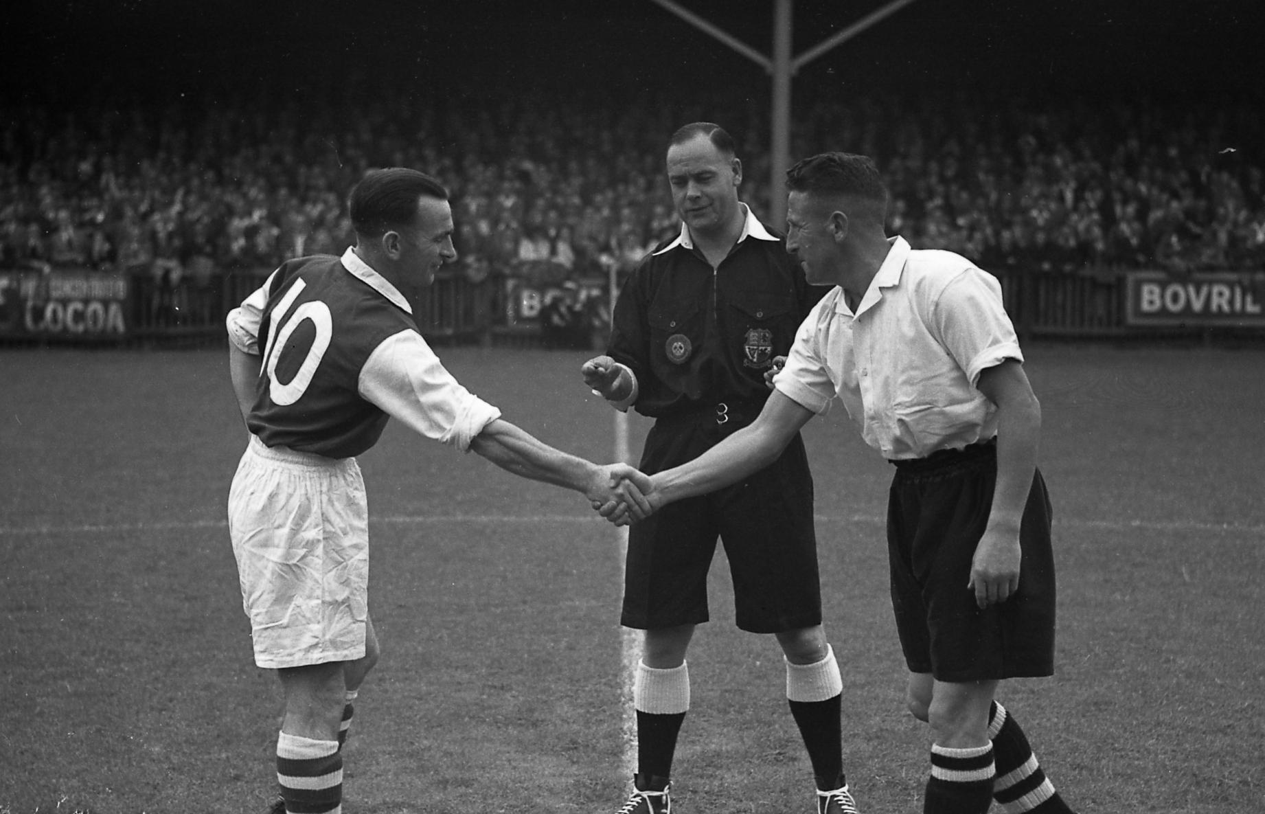 Bud Aherne shakes hands with Rotherham captain Gladstone Guest before the game, under the watchful eye of referee Mr Mann